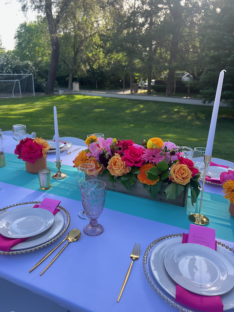 Elegant outdoor tablescape with vibrant floral centerpiece and sophisticated table styling